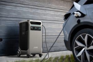 Anker Solix power unit charging a grey electric vehicle in front of a wooden wall