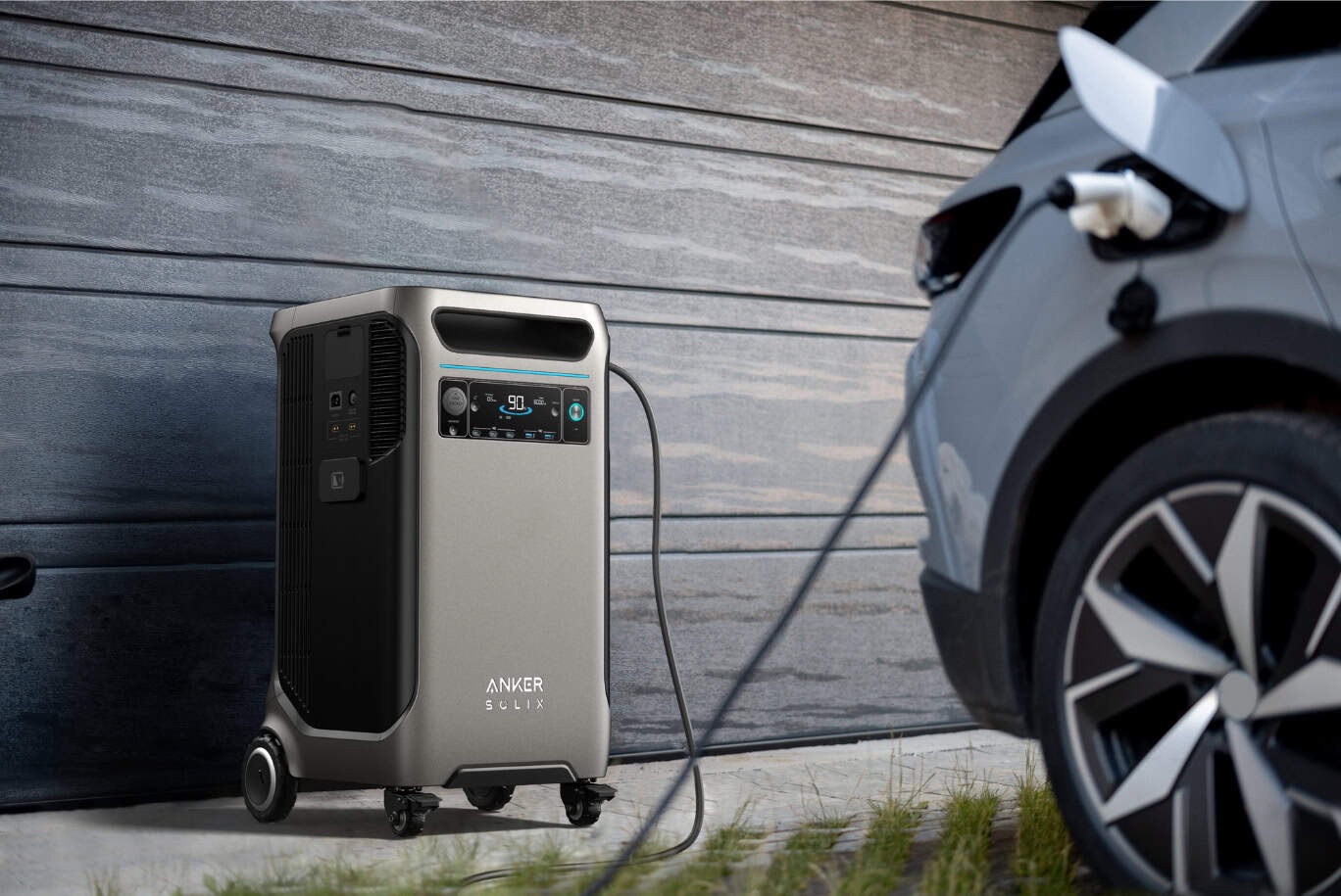 Anker Solix power unit charging a grey electric vehicle in front of a wooden wall